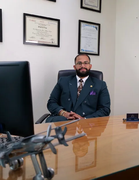 Dr. Edgardo Mateo con sus diplomas y certificaciones de neurocirugía en el consultorio